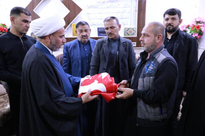 Siyonist saldırılarda şehit düşenlerin ailelerine İmam Hüseyin (a.s) sancağı hediye edildi